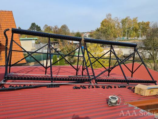 Solární kolektory na šikmé plechové střeše s natočením na jih.