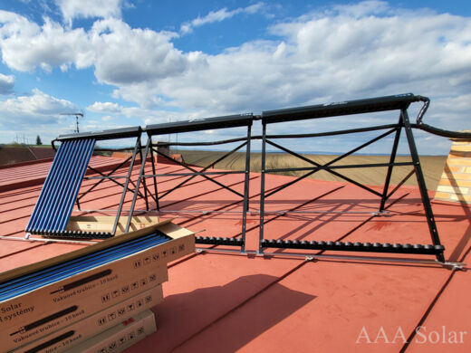Solární kolektory na šikmé plechové střeše s natočením na jih.