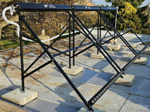 Solární trubicové kolektory na patkách na rovné střeše.