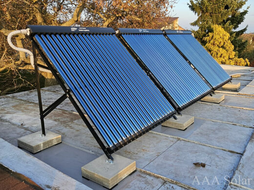 Solární trubicové kolektory na patkách na rovné střeše.